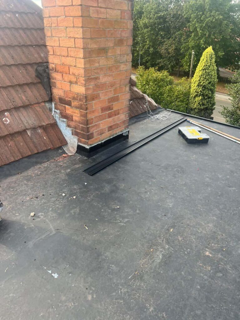 This is a photo of a flat roof which has just been repaired, there is also a chimney stack and some leadwork has also been dressed. Works carried out by Fulbourn Roofing Repairs