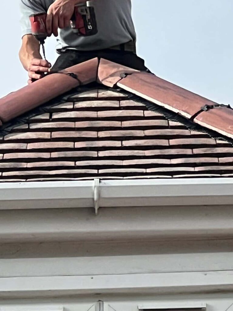 This is a photo of one of the operatives of Fulbourn Roofing Repairs installing new ridge tiles